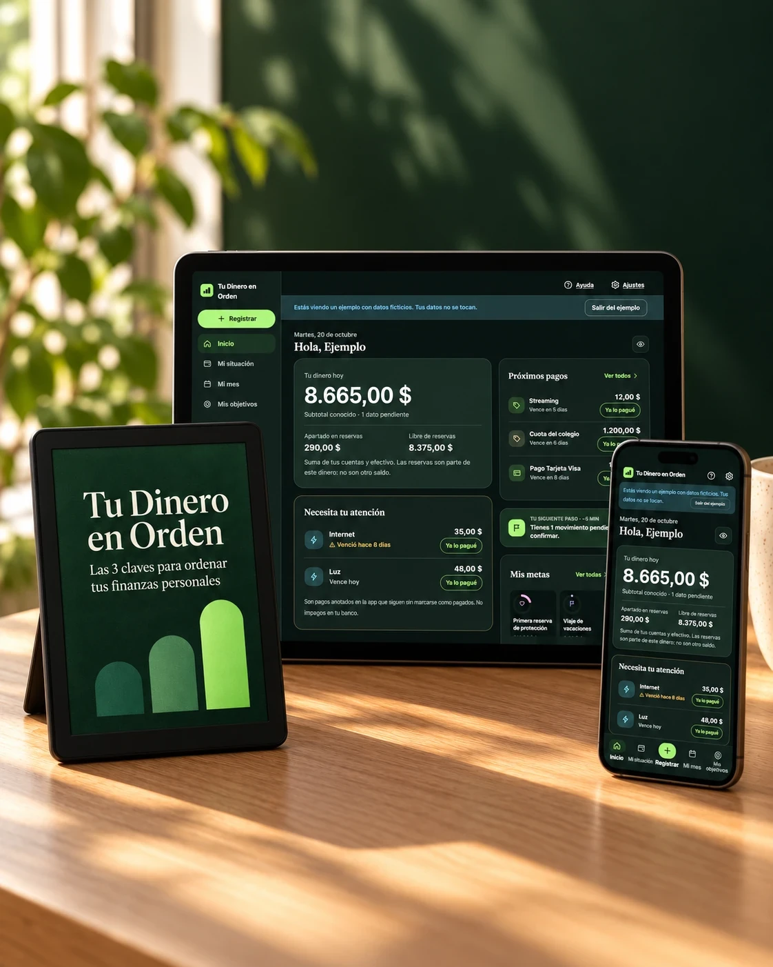 E-reader con la portada de Tu Dinero en Orden, junto a una tableta y un teléfono con la app de apoyo, sobre un escritorio de madera